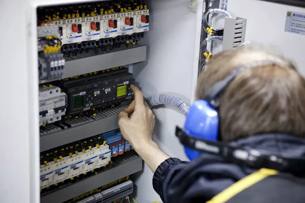 Technician working on a bridge equipment panel